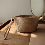Trousse de toilette pour femme en paille. Pochette de cosmétiques grande capacité avec fermeture éclaire. Offre un style naturel et un look épuré.
